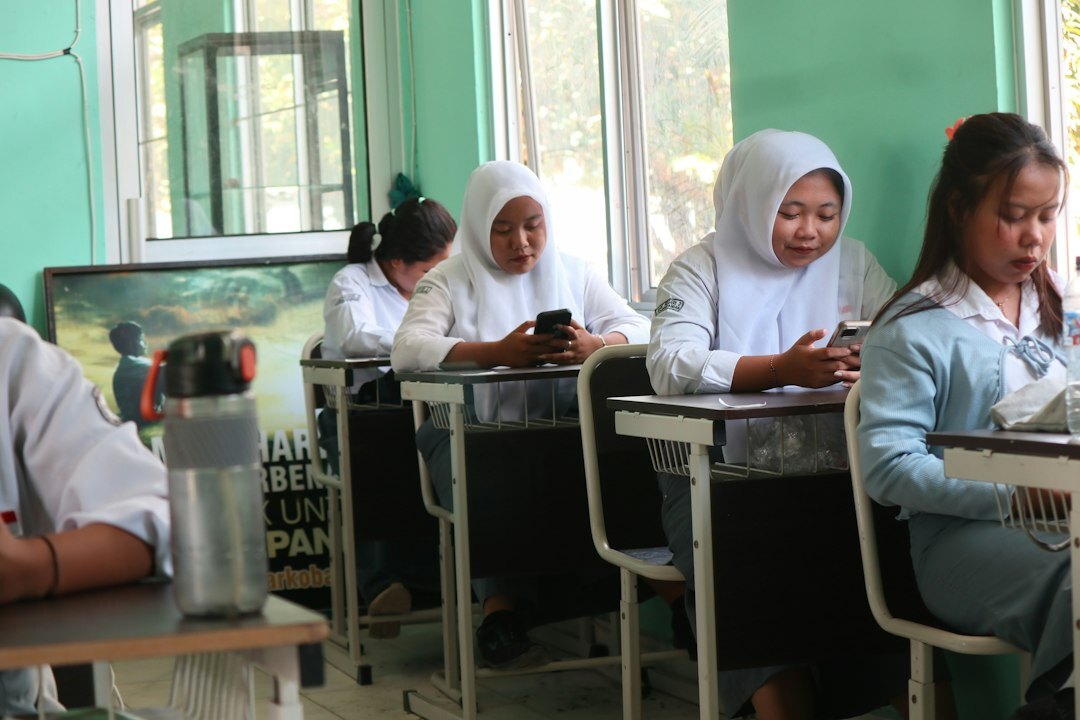 Students coding together on laptops in a classroom