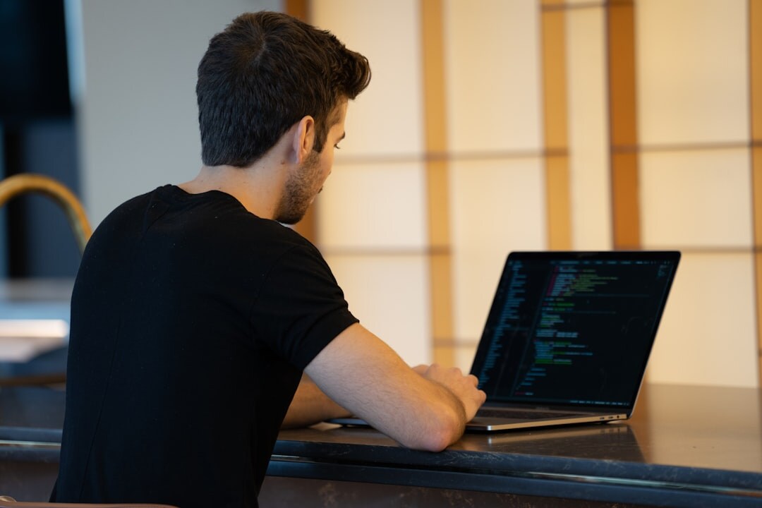 programmer coding on laptop